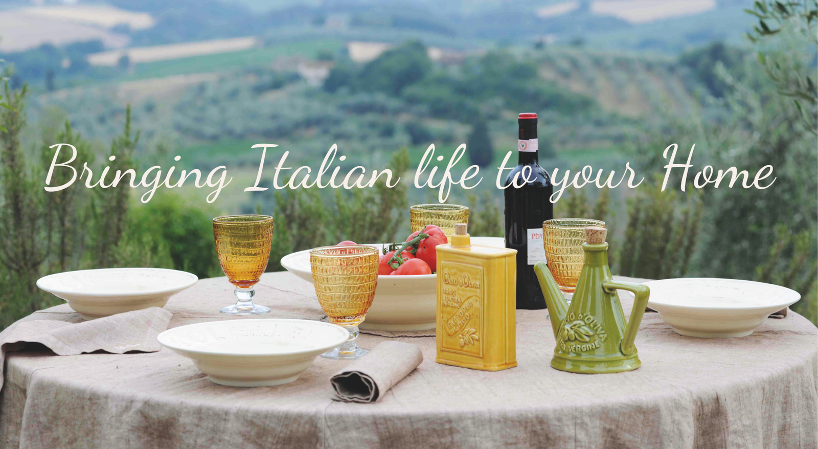 Gedekte tafel met handgemaakt Italiaans servies en olijfolie kannetjes in Toscaans landschap